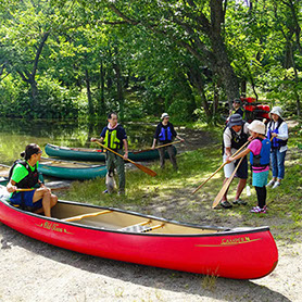 十和田湖カヌーツアーのレクチャー風景。ガイドが子どもにパドルの漕ぎ方を伝えている