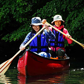 初めて乗るカナディアンカヌーで漕ぐ練習をしている女性二人