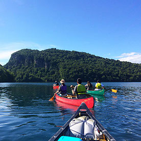 カナディアンカヌーでしかいけない入り江を目指し広い十和田湖を漕ぎ出す参加者